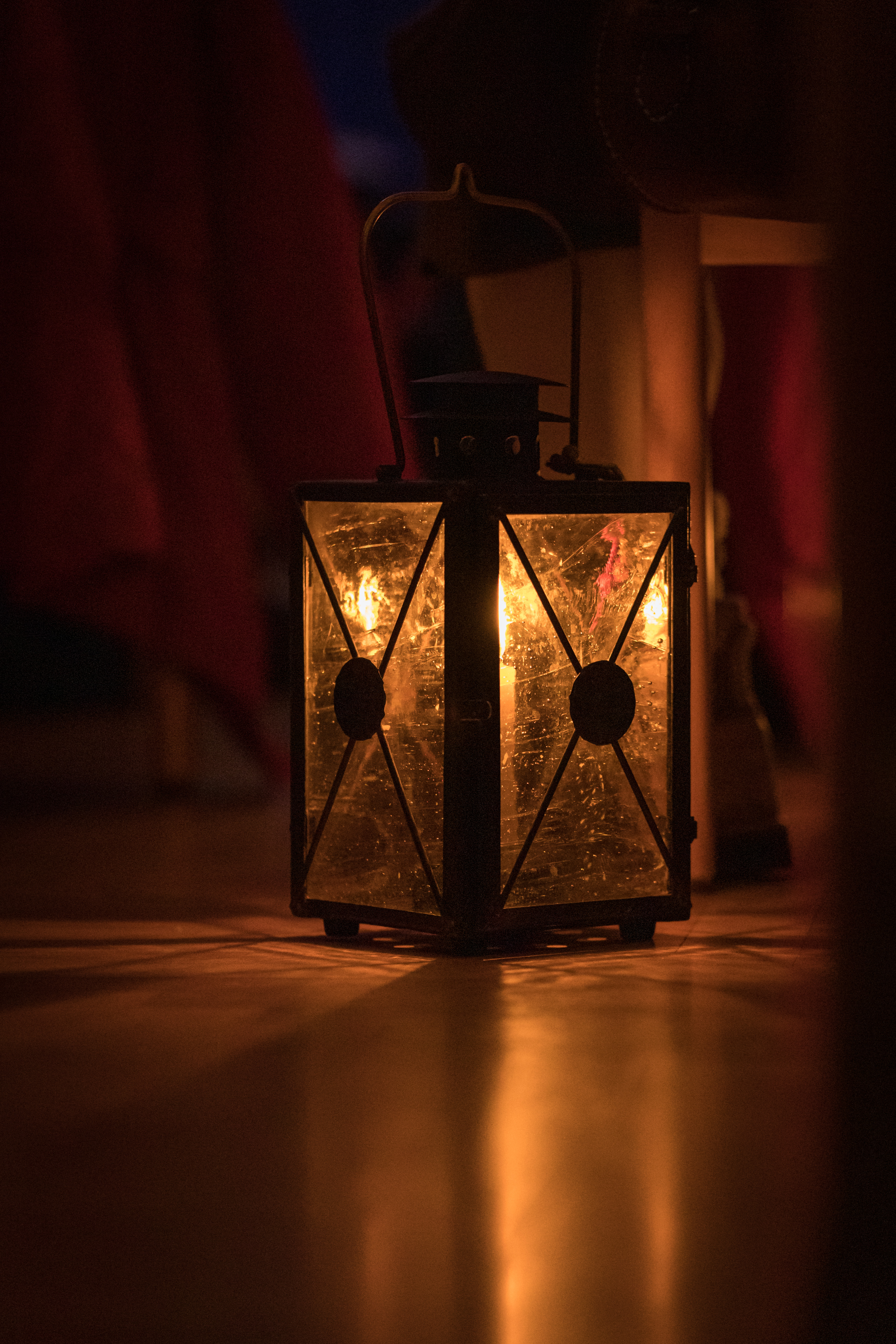 Eine Laterne bringt warmes Licht in einen dunklen Raum.