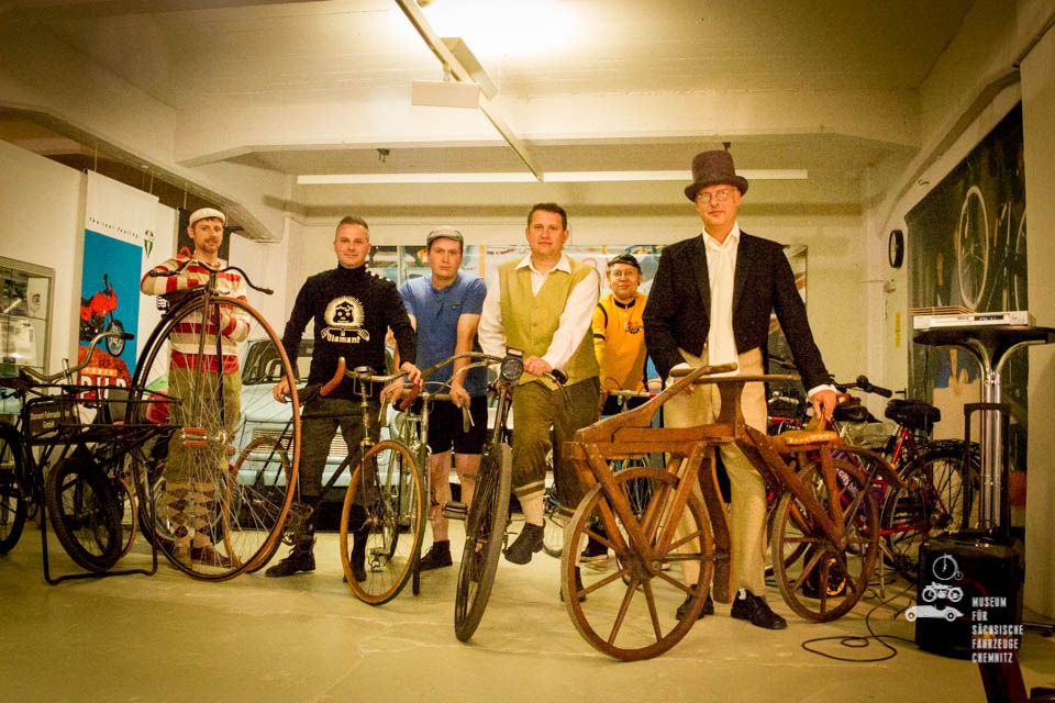 Das Foto zeigt mehrere historische Fahrräder und sechs Fahrer in Fahrradkleidung nach historischem Vorbild.