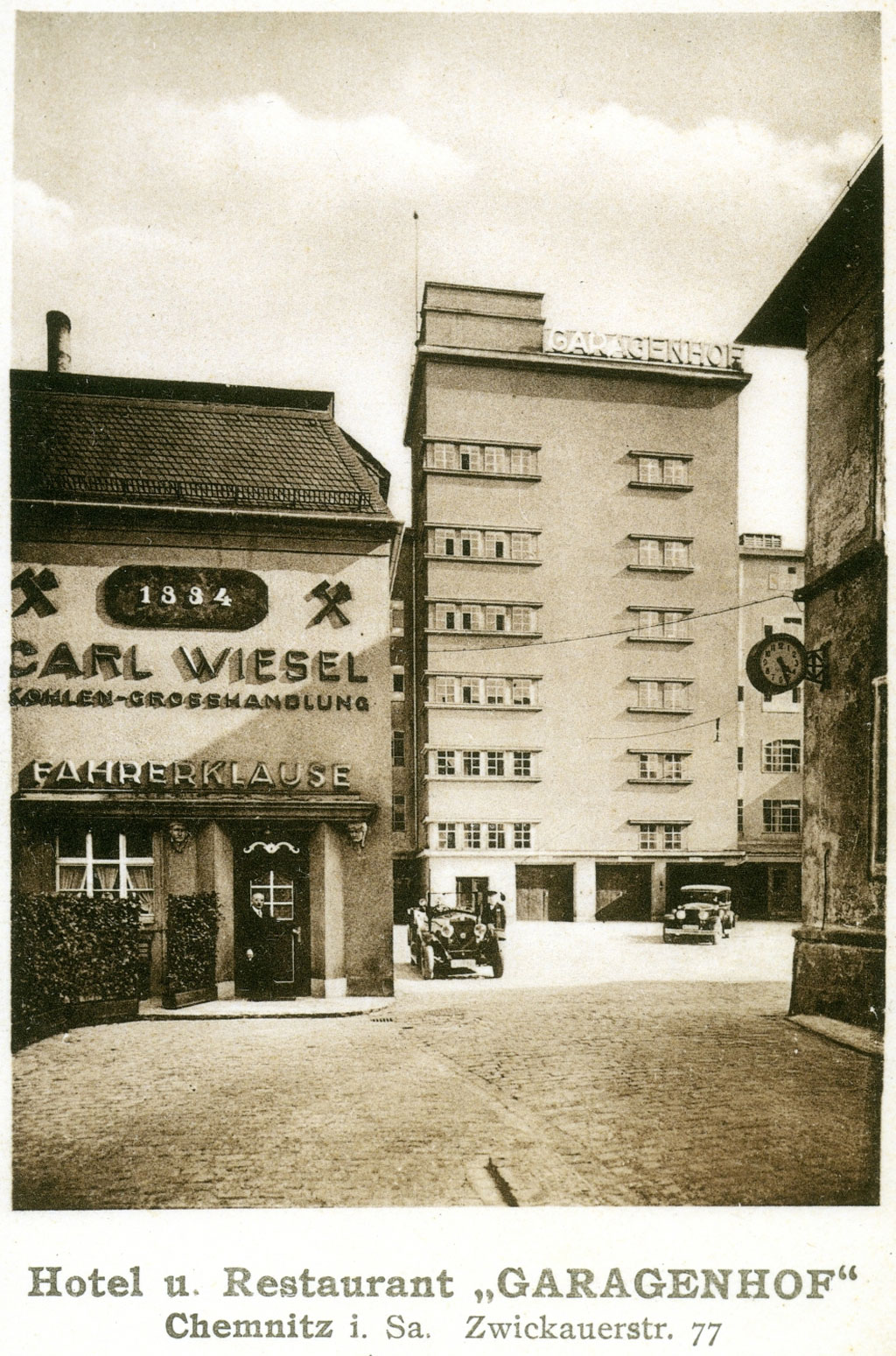 Auf der historischen Postkarte ist die sechsgeschossige Hochgarage Chemnitz zu sehen, davor ein niedrigerer Anbau. Unter dem Foto steht "Hotel und Restaurant 'Garagenhof'. Chemnitz in Sachsen, Zwickauer Straße 77".