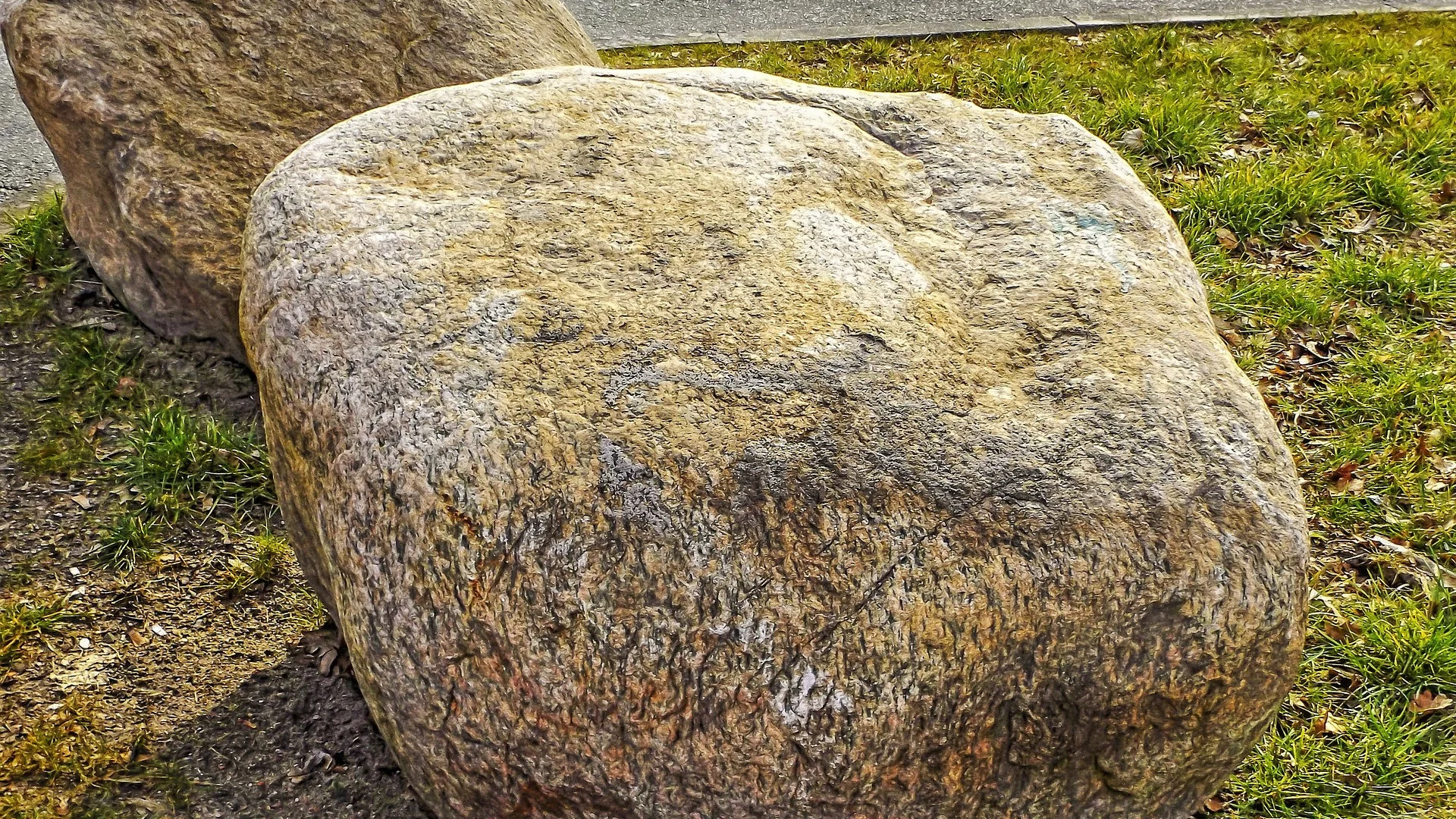Ein großer Stein – ein Findling – auf einer Wiese