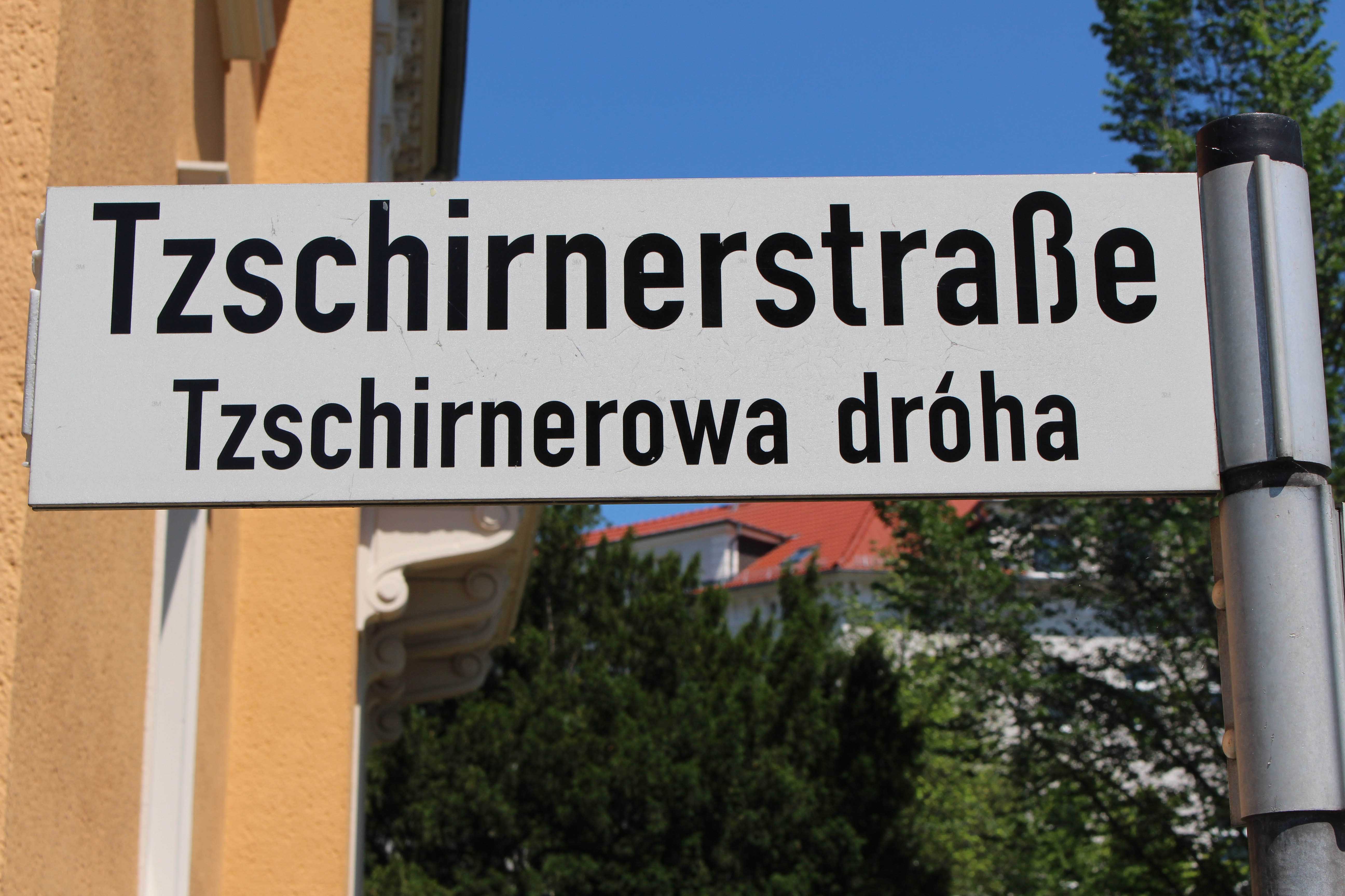 Nahaufnahme eines Straßenschildes, auf dem auf Deutsch "Tzschirnerstraße" und auf Sorbisch "Tzschirnerowa dróha" steht