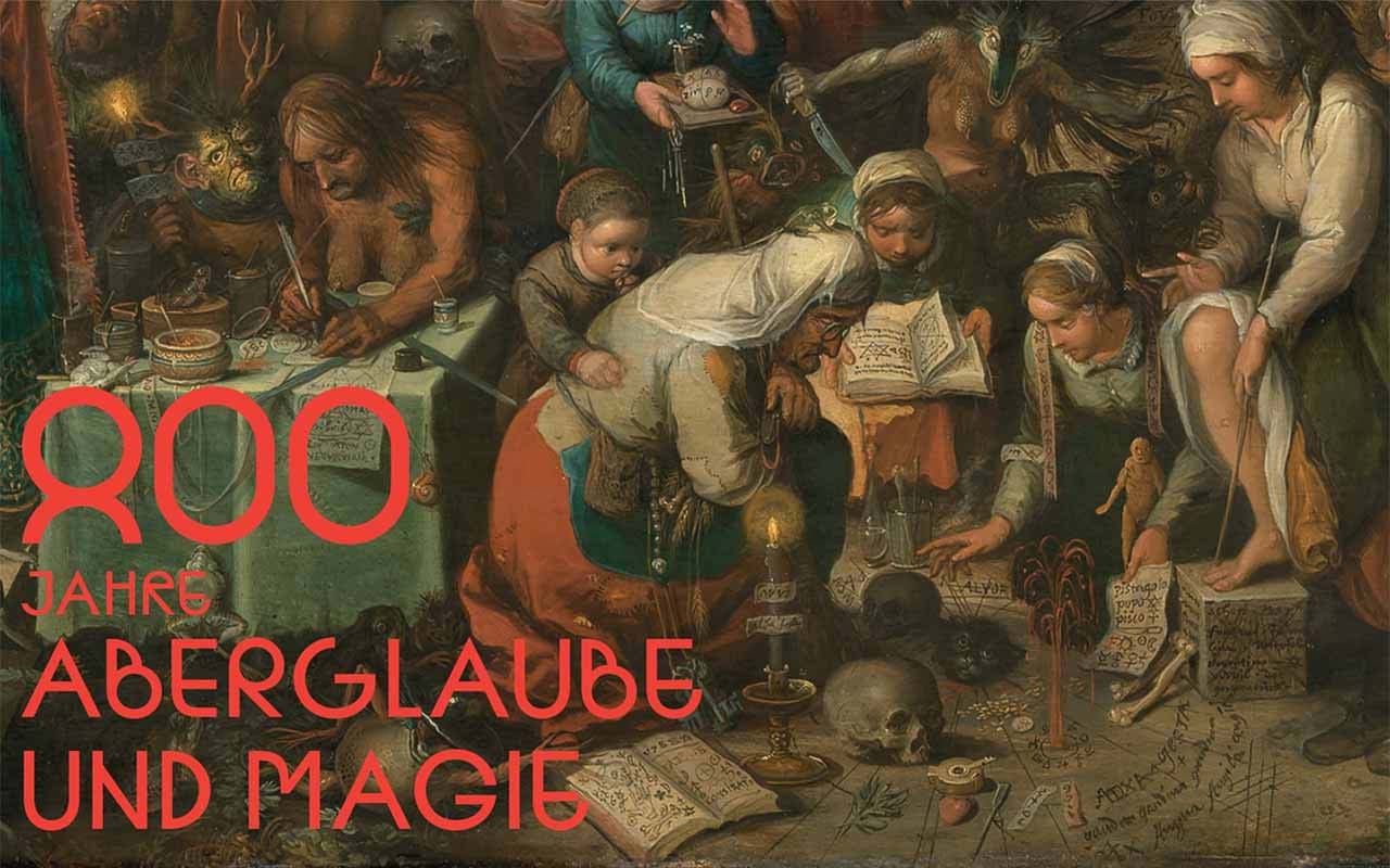 Das Plakat zeigt den Titel "800 Jahre Aberglaube und Magie" in roter Schrift vor einem historischen Gemälde, auf dem mehrere Personen in einer Szene mit Büchern, Kerzen und rituellen Gegenständen dargestellt sind.