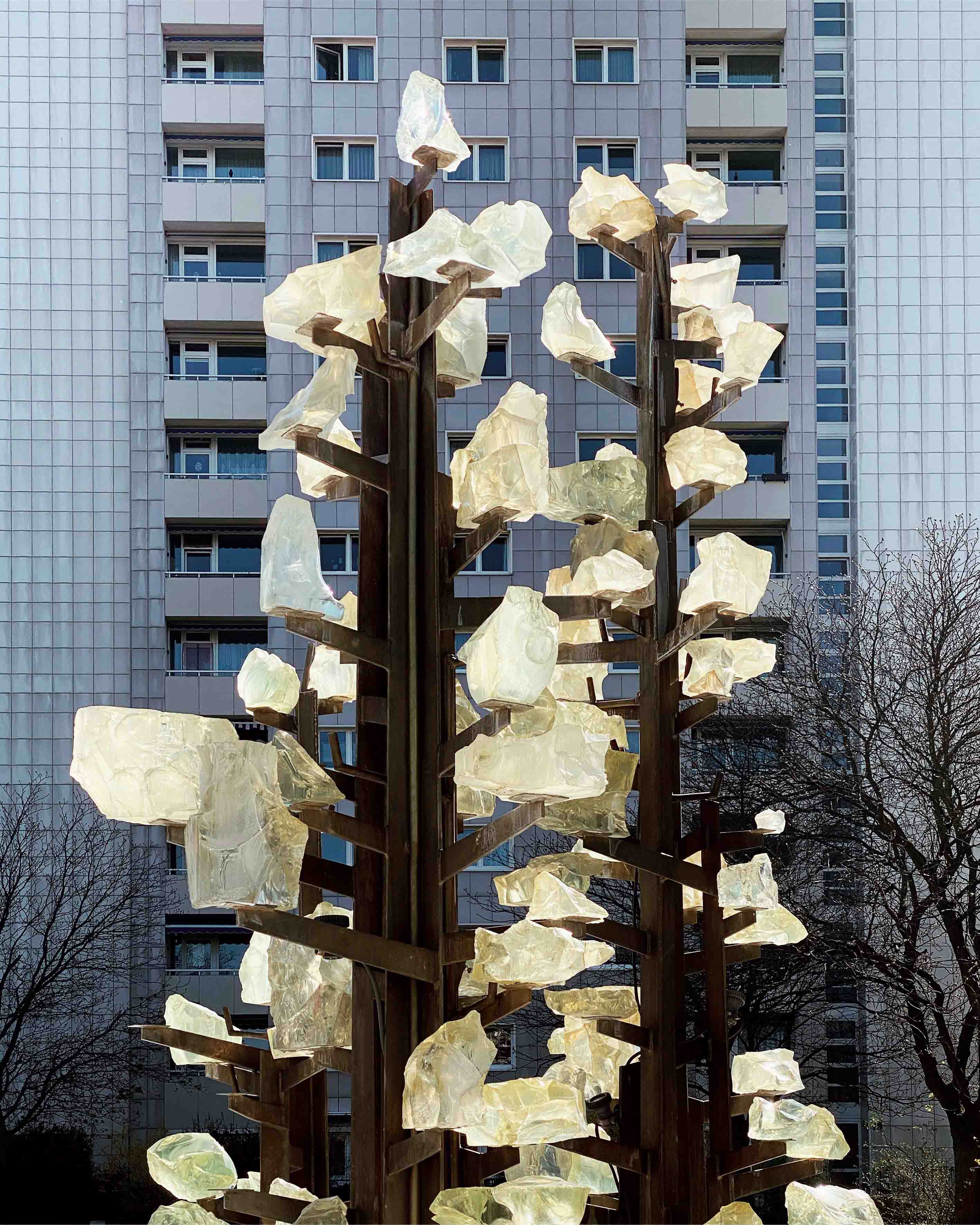 Das Foto zeigt Anne Pöhlmanns Werk „Brunnen“ aus der Serie „85 Tage Dresden“, geschaffen 2022. Zu sehen ist eine Detailaufnahme eines modernen Brunnens vor der Fassade eines Hochhauses aus DDR-Zeit.